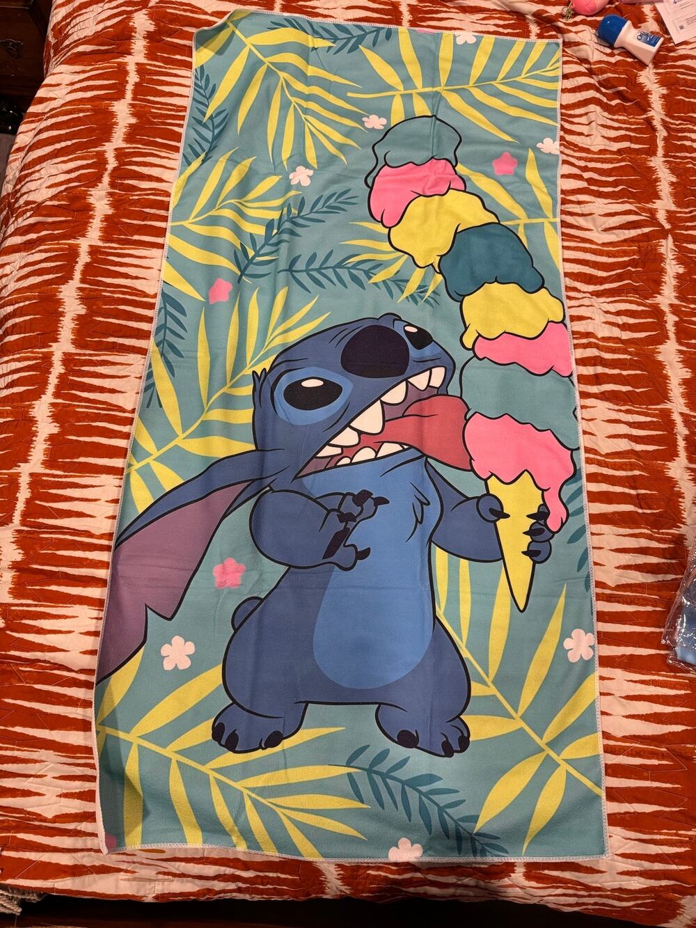Stitch beach towel with Stitch holding a multi-colored ice cream palm leaves